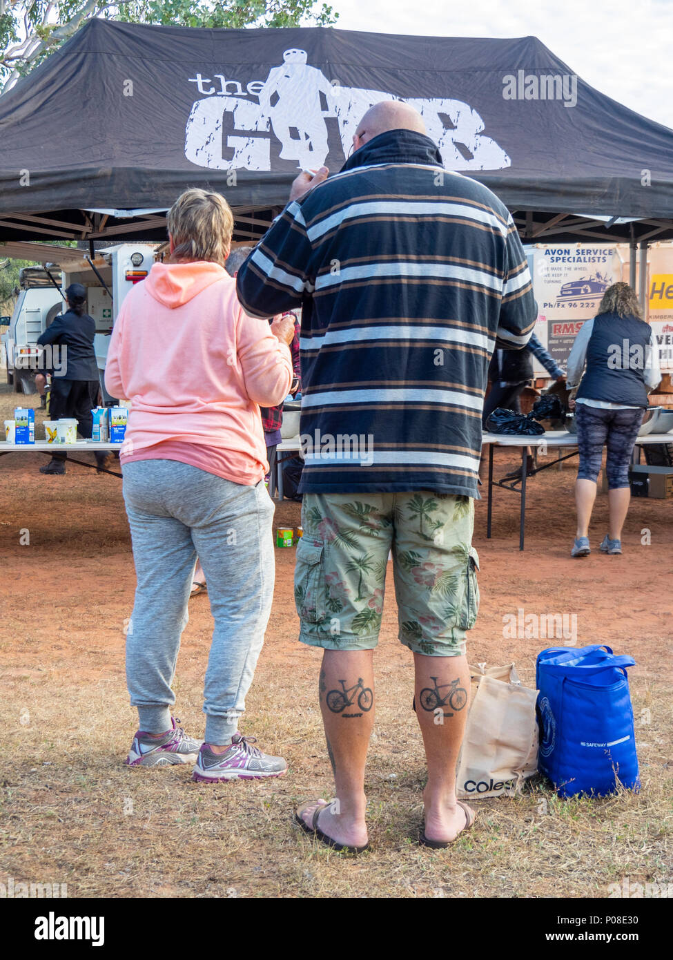 Gibb Challenge 2018 un paio in piedi presso il campeggio, il maschio con tatuaggi di un gigante di mountain bike e biciclette speciali vitelli Kimberley WA Australia. Foto Stock