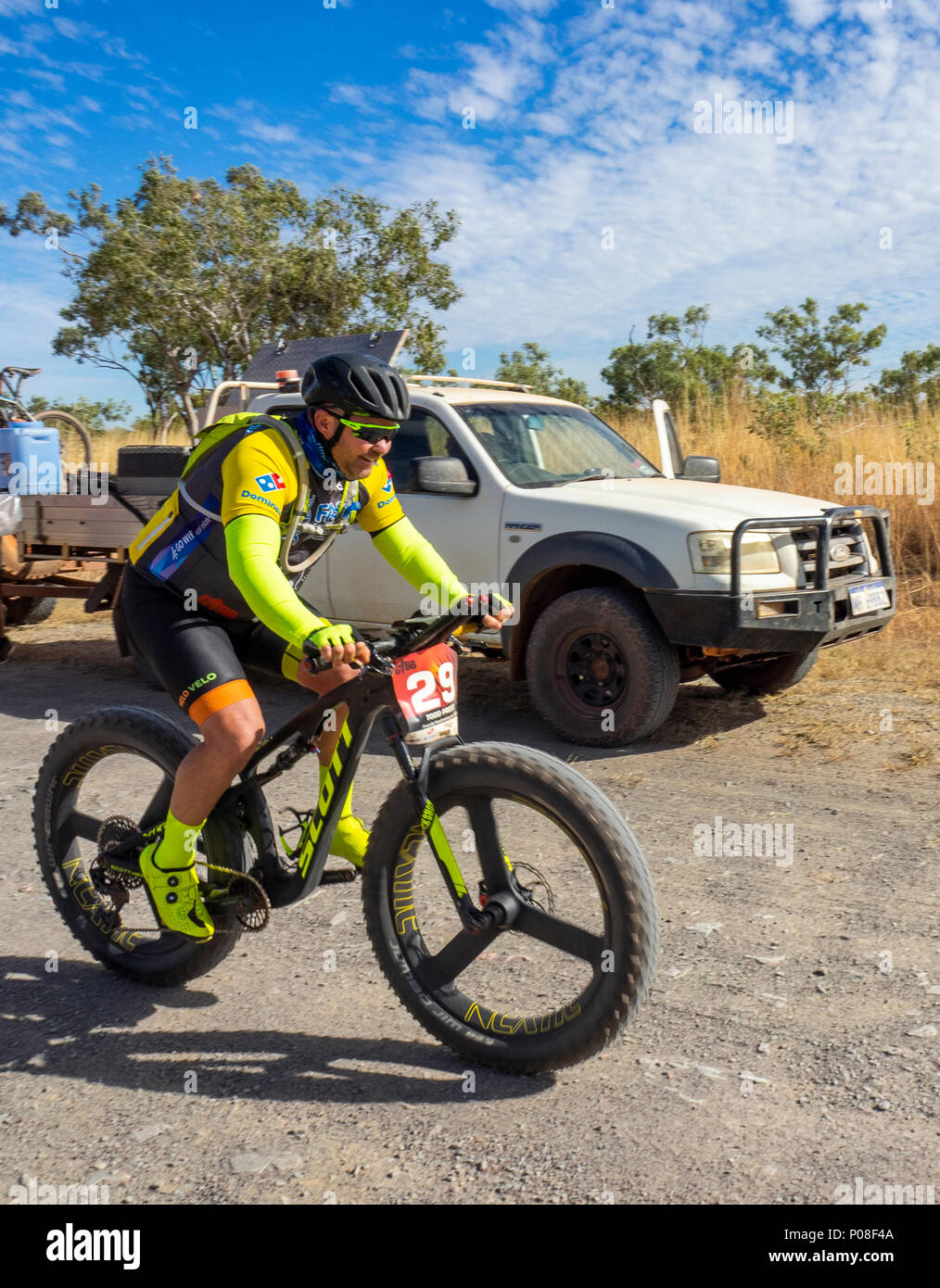 Un Gibb Challenge 2018 ciclista passato a cavallo di un veicolo di supporto e rimorchio su sporco Gibb River Road WA Kimberley Australia. Foto Stock