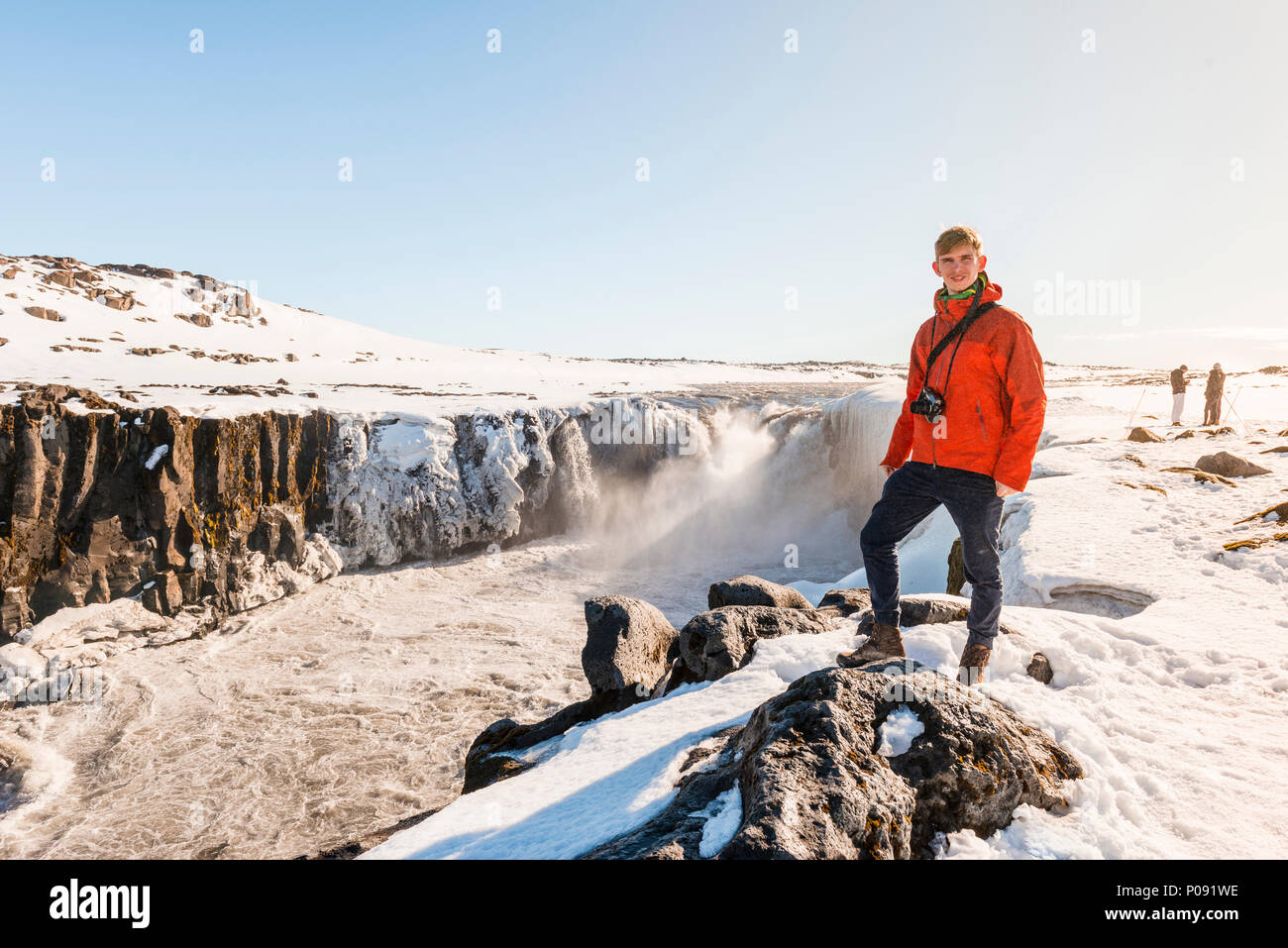 L'uomo con la fotocamera in piedi sul bordo, Selfoss cascata in inverno, gorge, Nord Islanda Islanda Foto Stock