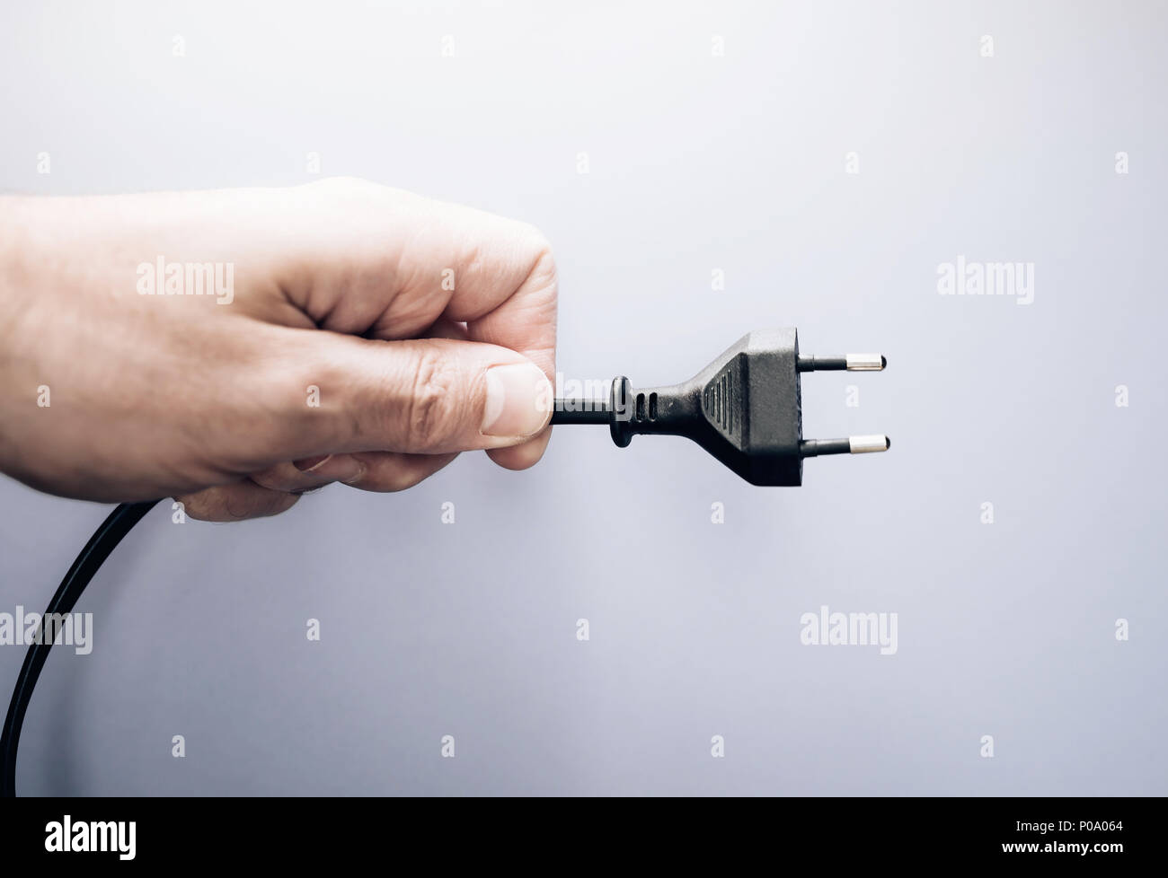 Maschio di mano azienda spina elettrica Foto Stock