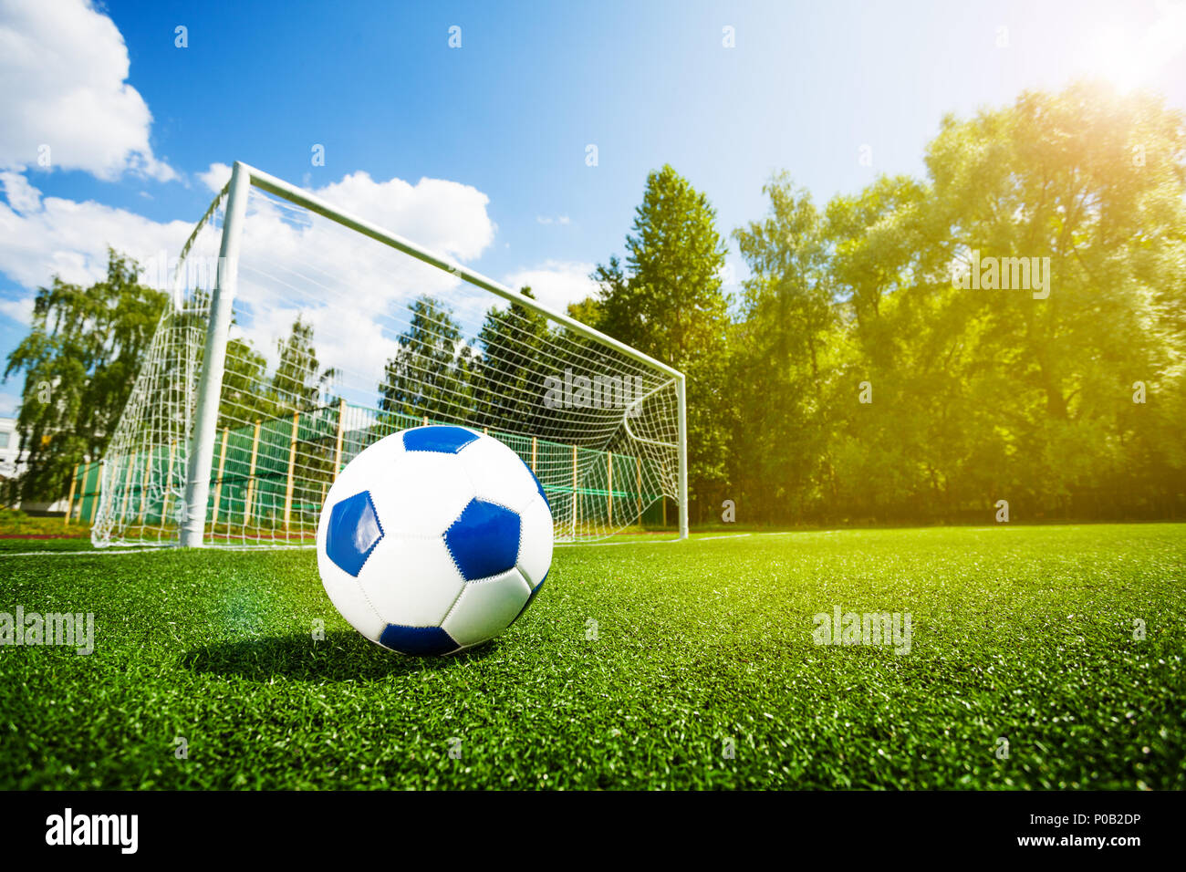 Footfall Pallone da calcio e delle porte sul campo di gioco oltre il cielo  blu Foto stock - Alamy