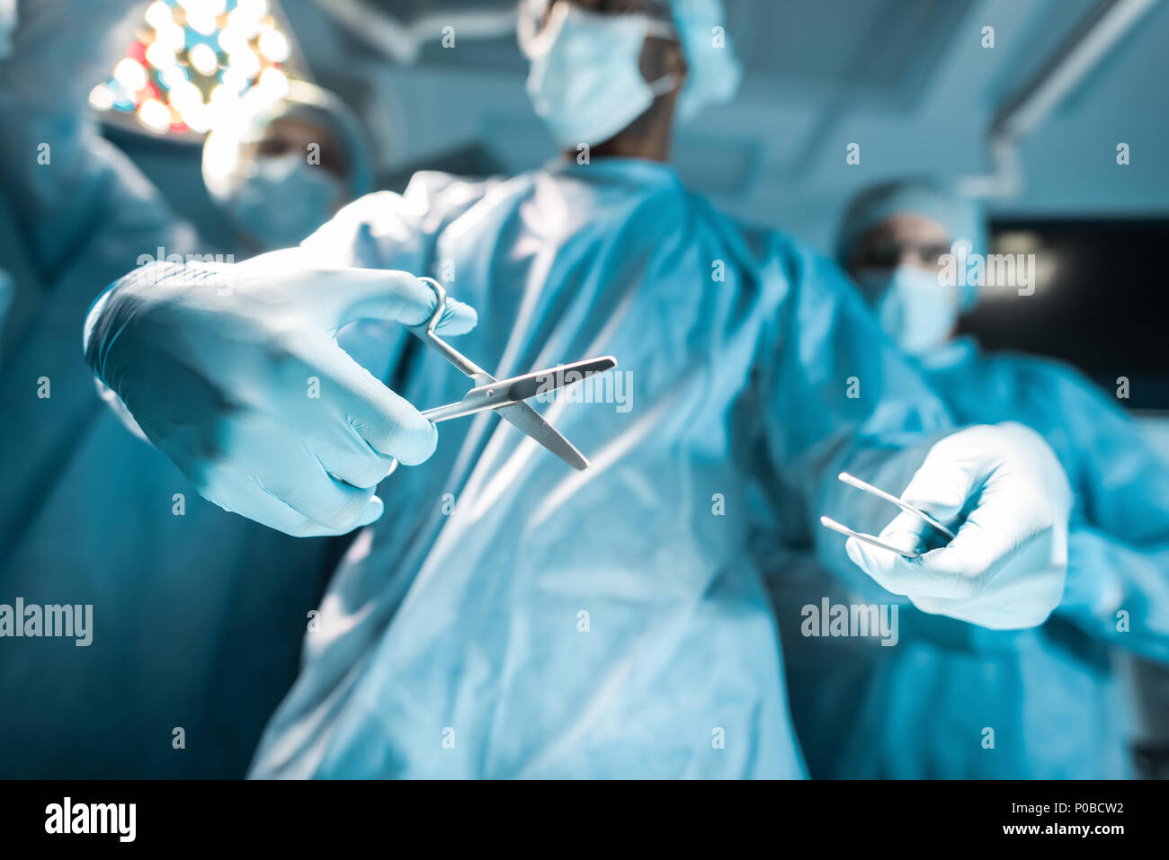 Vista dal basso dei chirurghi multiculturale con strumenti medicali Foto Stock