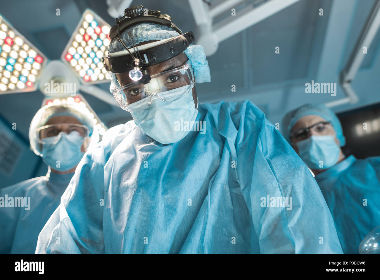 Vista dal basso del african american chirurgo guardando la fotocamera Foto Stock