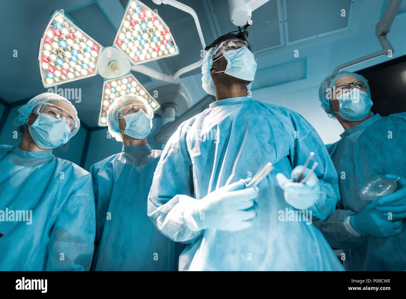 Vista dal basso dei chirurghi multiculturale che guarda lontano Foto Stock