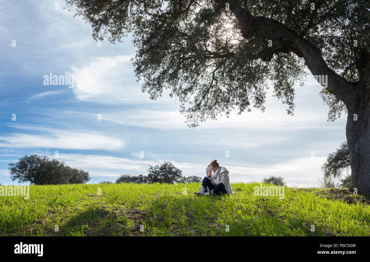 Madre utilizza smartphone con suo figlio invece di godere la natura. Telefono cellulare dipendenza guai concept Foto Stock