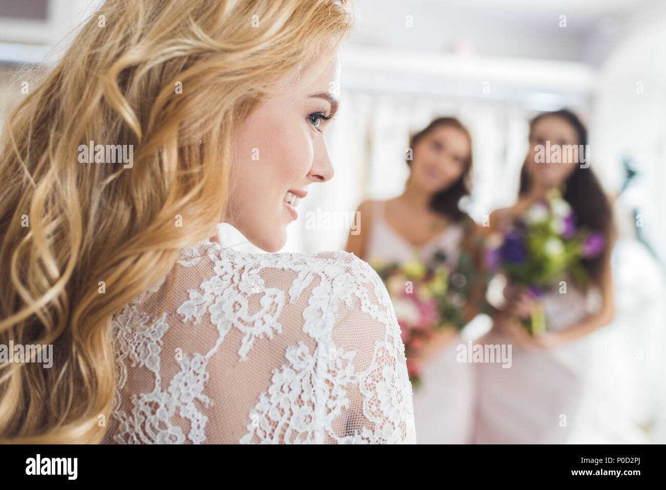 Sposa Abito in pizzo e damigelle con fiori in wedding fashion shop Foto Stock