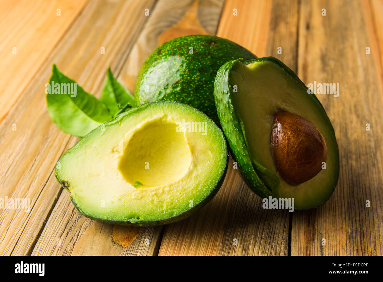Fresco frutto di avocado su una tavola di legno Foto Stock