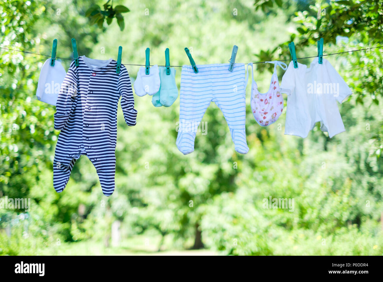 Vestiti del bambino su stendibiancheria in giardino Foto Stock