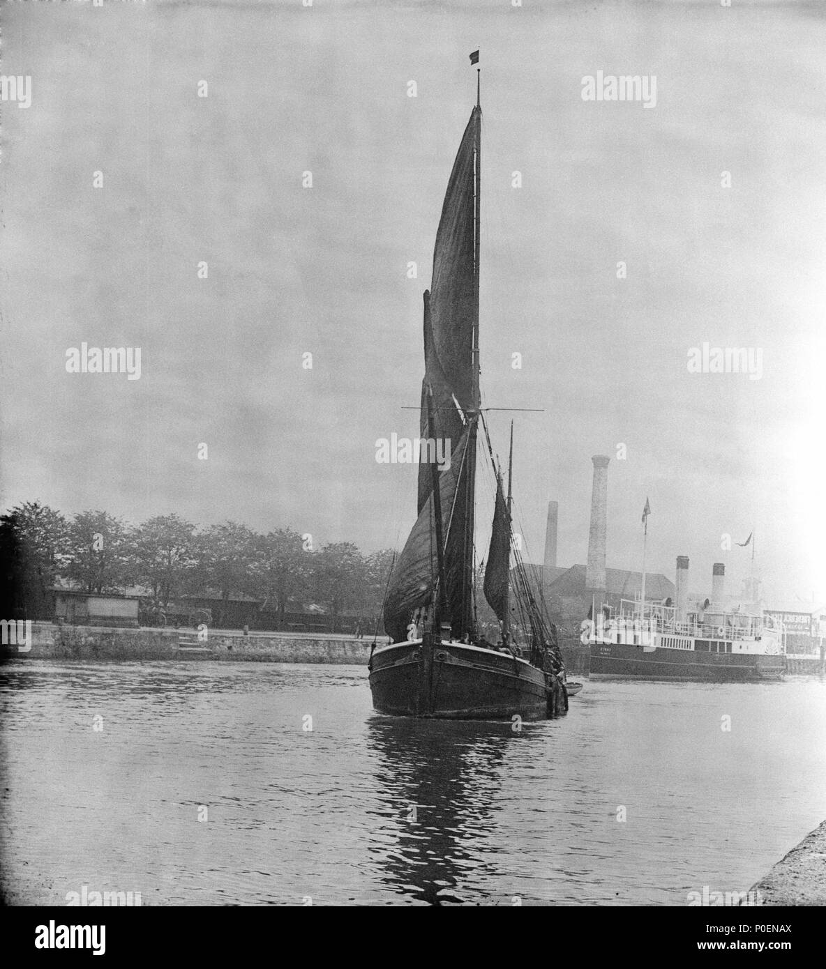 . Inglese: una vista attraverso il nuovo taglio a Ipswich con un misterioso spritsail barge sotto la vela lasciando. Una vista attraverso il nuovo taglio a Ipswich con un misterioso spritsail barge sotto la vela lasciando. La pala ferry 'Essex' (1896) è al suo posto di ormeggio in background. Una vista attraverso il nuovo taglio a Ipswich con un misterioso spritsail barge sotto la vela lasciando. . Circa 1904. Smiths Suitall Ltd 241 Una vista attraverso il nuovo taglio a Ipswich con un misterioso spritsail barge sotto la vela lasciando. RMG P27528 Foto Stock