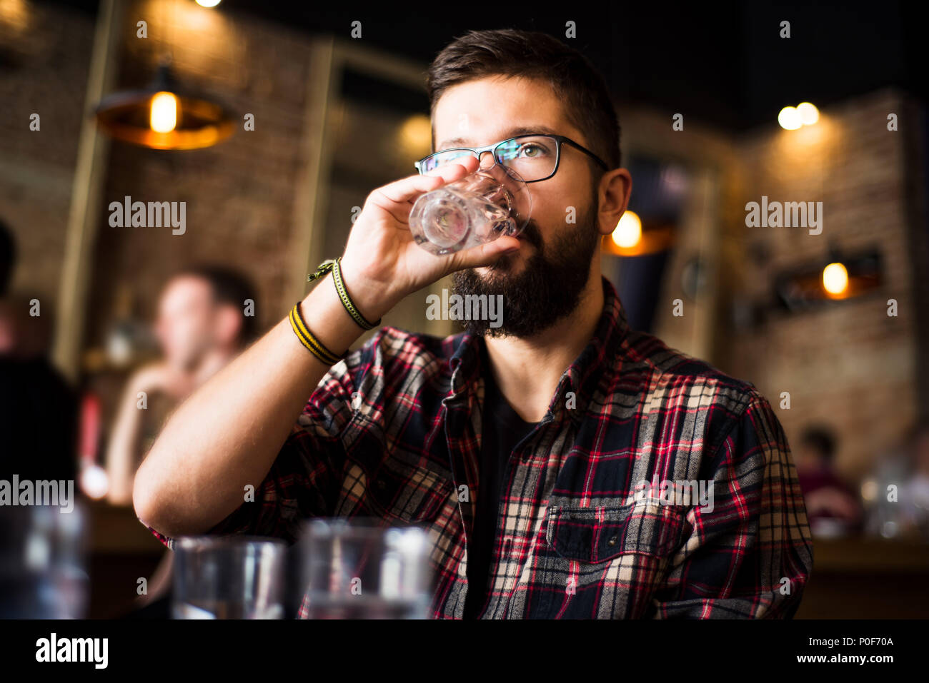 Tanga barbuto uomo acqua potabile in un caffè bar Foto Stock