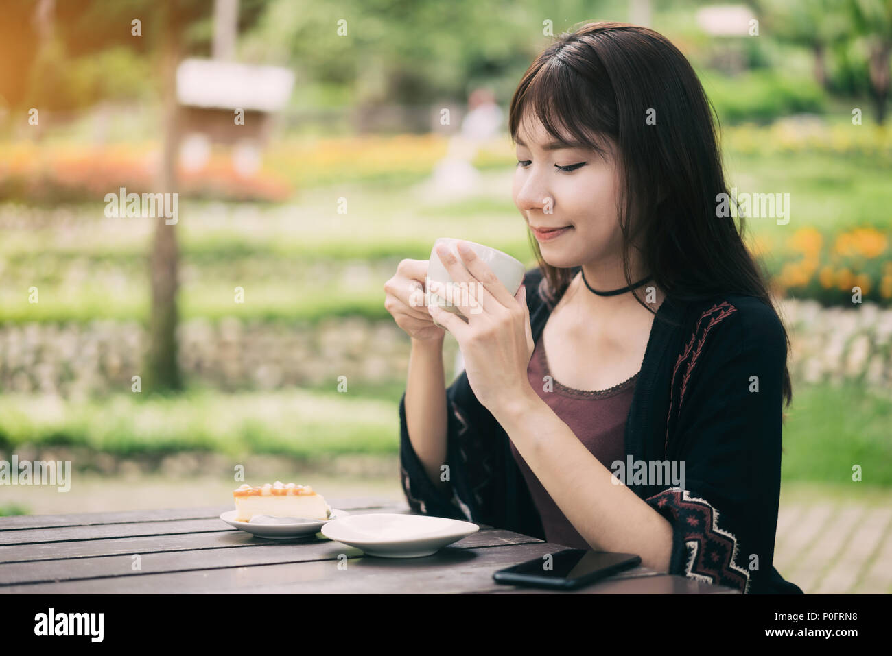 Donne asiatiche rilassante nel giardino di casa con la tazza di caffè e la sensazione di refresh. Foto Stock