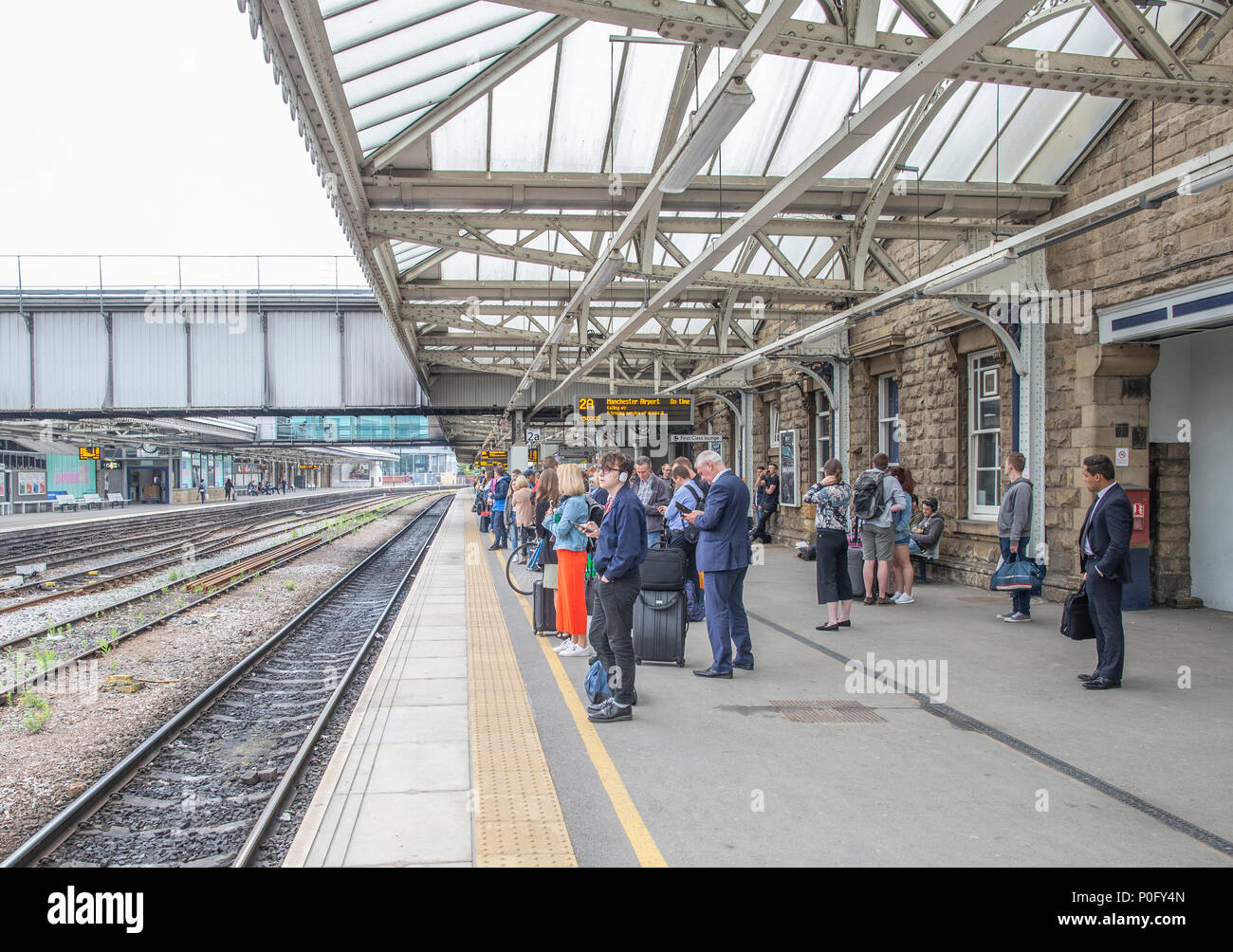 Pendolari in attesa di un treno in Sheffiled stazione ferroviaria Foto Stock