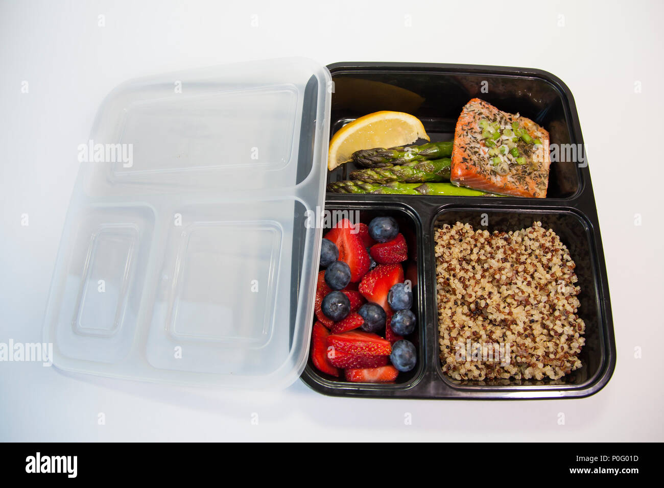 Pianificate i pasti in contenitori - salmone con asparagi, quinoa e frutta fresca. Foto Stock
