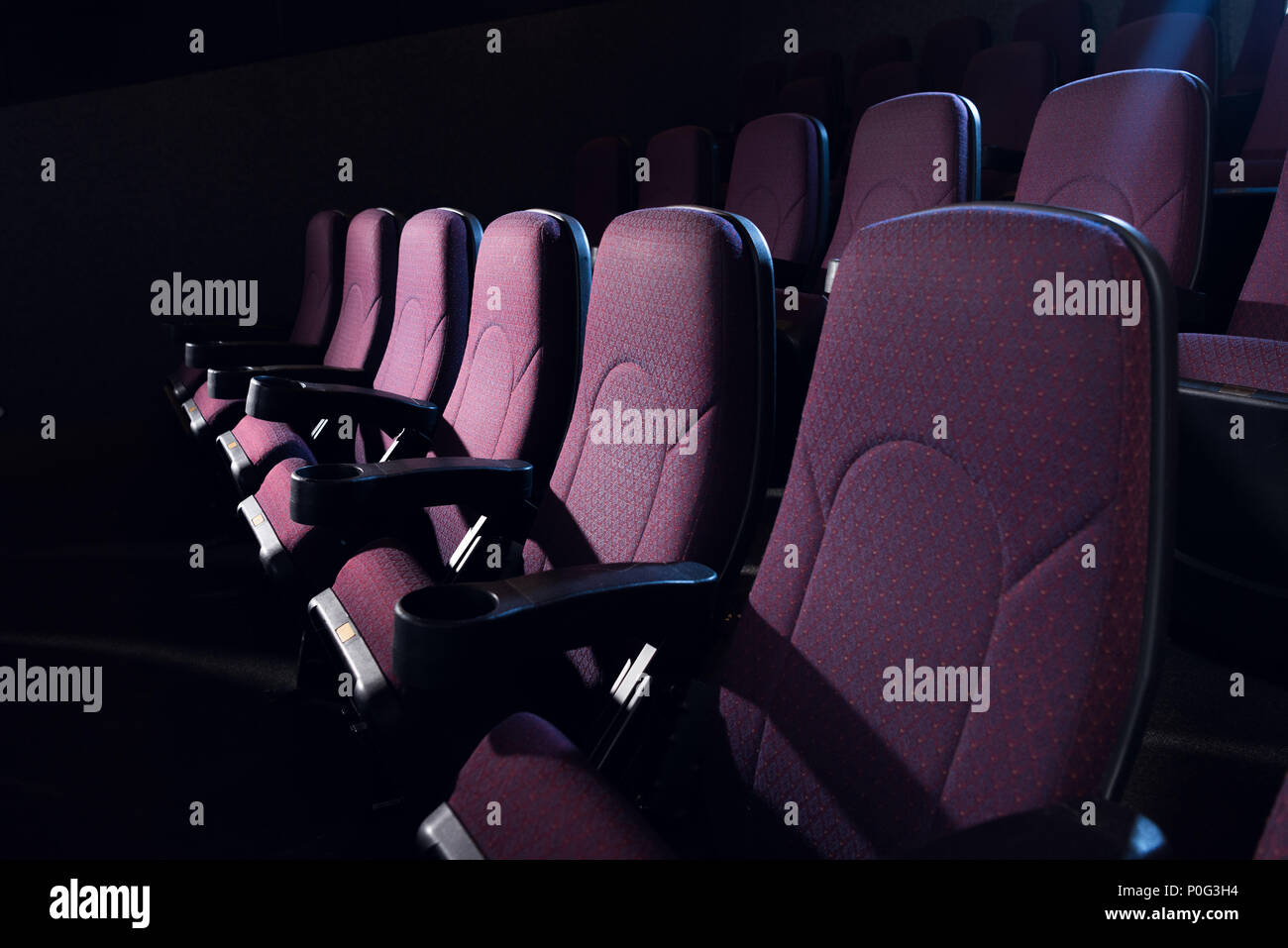 Sedi di rosso nella vuota scuri cinema Foto Stock