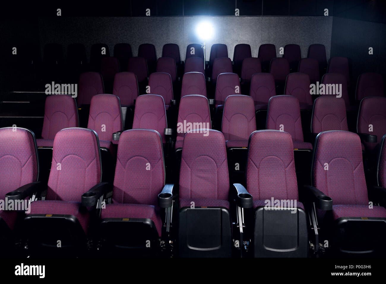 Sedi di rosso nella vuota scuri cinema con retro illuminazione Foto Stock