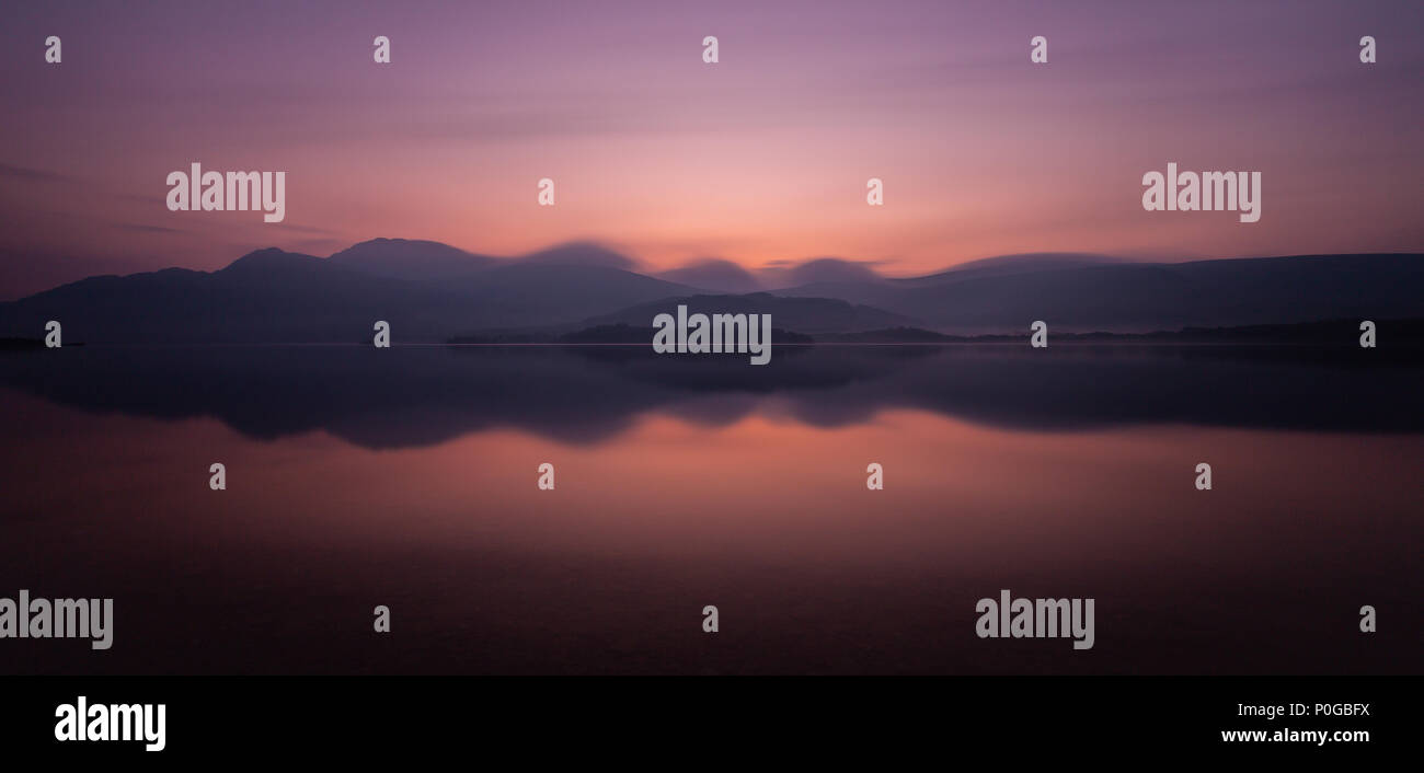 Una lunga esposizione fotografia di Loch Lomond , il lago si trova in Scozia, nel Regno Unito , in Europa presi in una nebbiosa mattina di primavera in giugno Foto Stock