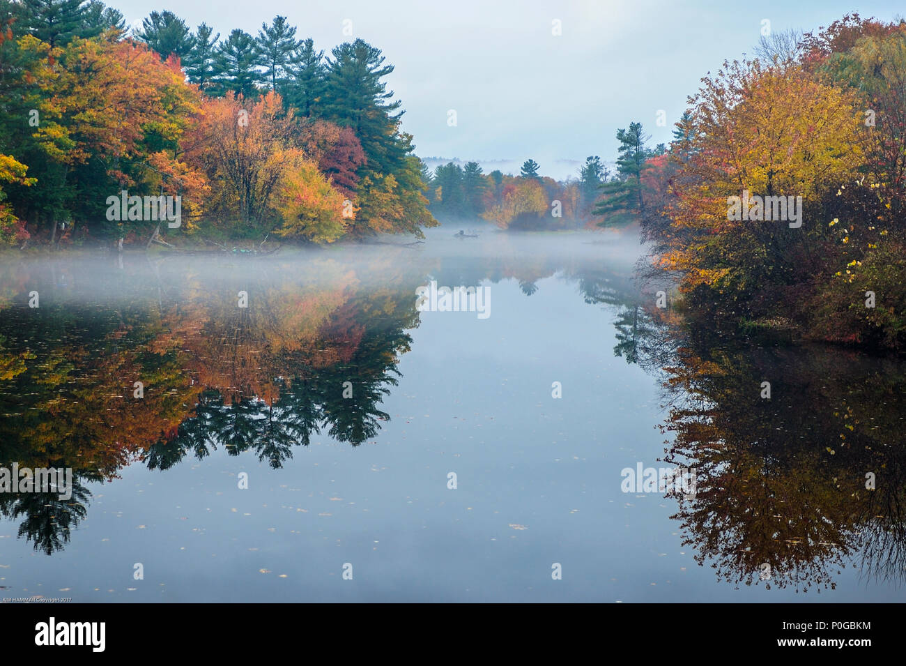 La nebbia si blocca in cima all'immagine riflessa del new England's i colori dell'autunno. Foto Stock