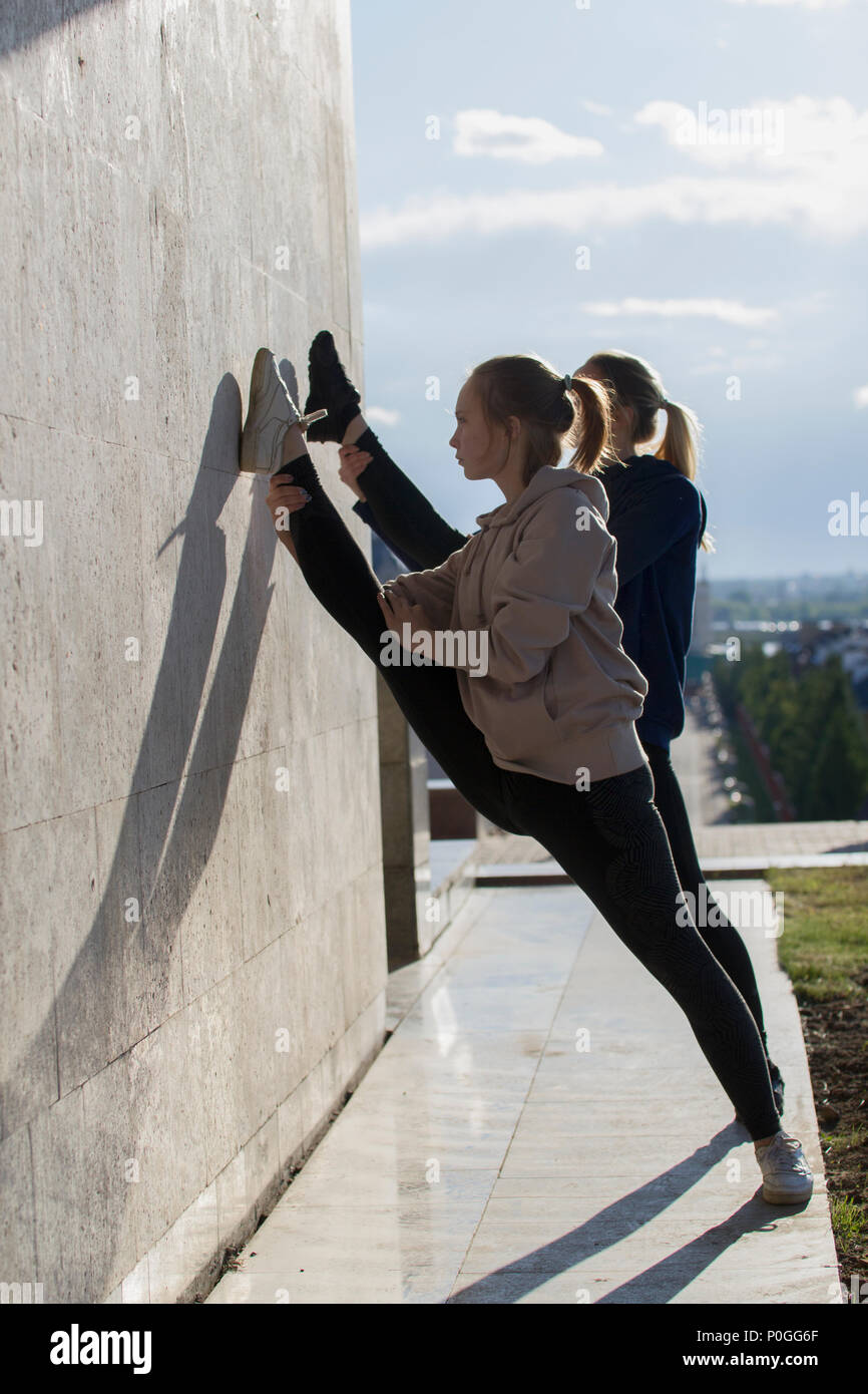 Due giovani donne attraenti facendo acrobazie con il paesaggio sullo sfondo Foto Stock
