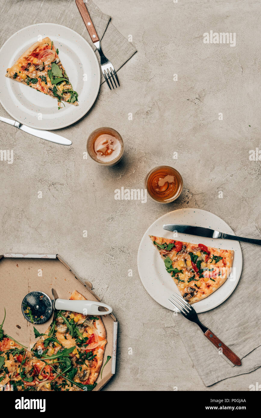 La cena modello con fette di pizza su piatti e bicchieri su sfondo chiaro Foto Stock