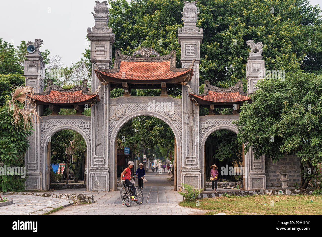 Hoa Lu, Vietnam - Ottobre 28, 2017: uomo, su una bicicletta entrando antica capitale del Vietnam Hoa lu. È stata la città capitale nel decimo e undicesimo centuri Foto Stock