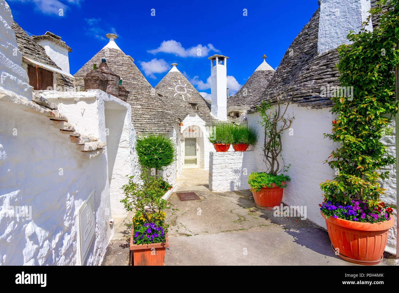 Alberobello Puglia, Italia: tipiche case costruite con muri in pietra a secco e tetti conici, in una bella giornata, Puglia Foto Stock