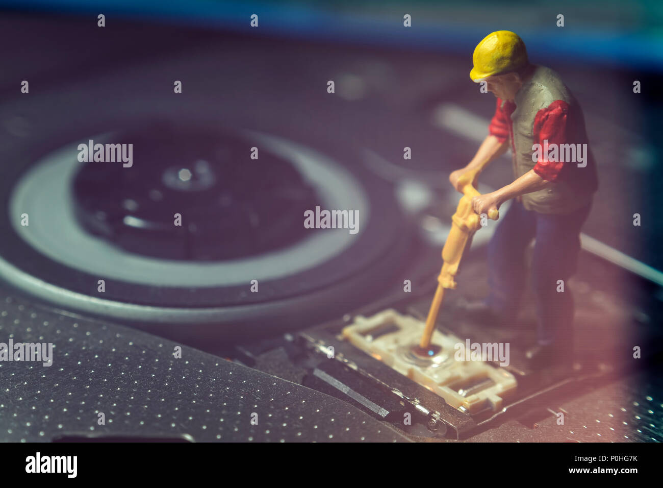 Lavoratore in miniatura che fissa la lente di DVD Foto Stock