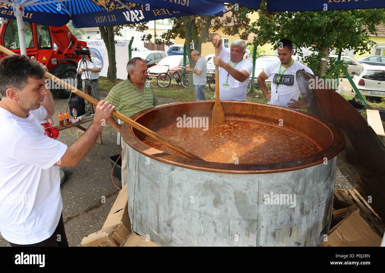 Temerin, Serbia. Il 9 giugno, 2018. Persone agitare lentamente a circa 2.000 litri di fagioli bianchi' la zuppa in un gigantesco calderone durante il 'semplice come semi di soia " festival in Temerin, Serbia, il 9 giugno 2018. Migliaia di persone si sono radunate sabato in Serbia del nord di città di Temerin per celebrare il 'semplice come semi di soia " festival. Credito: Wang Huijuan/Xinhua/Alamy Live News Foto Stock