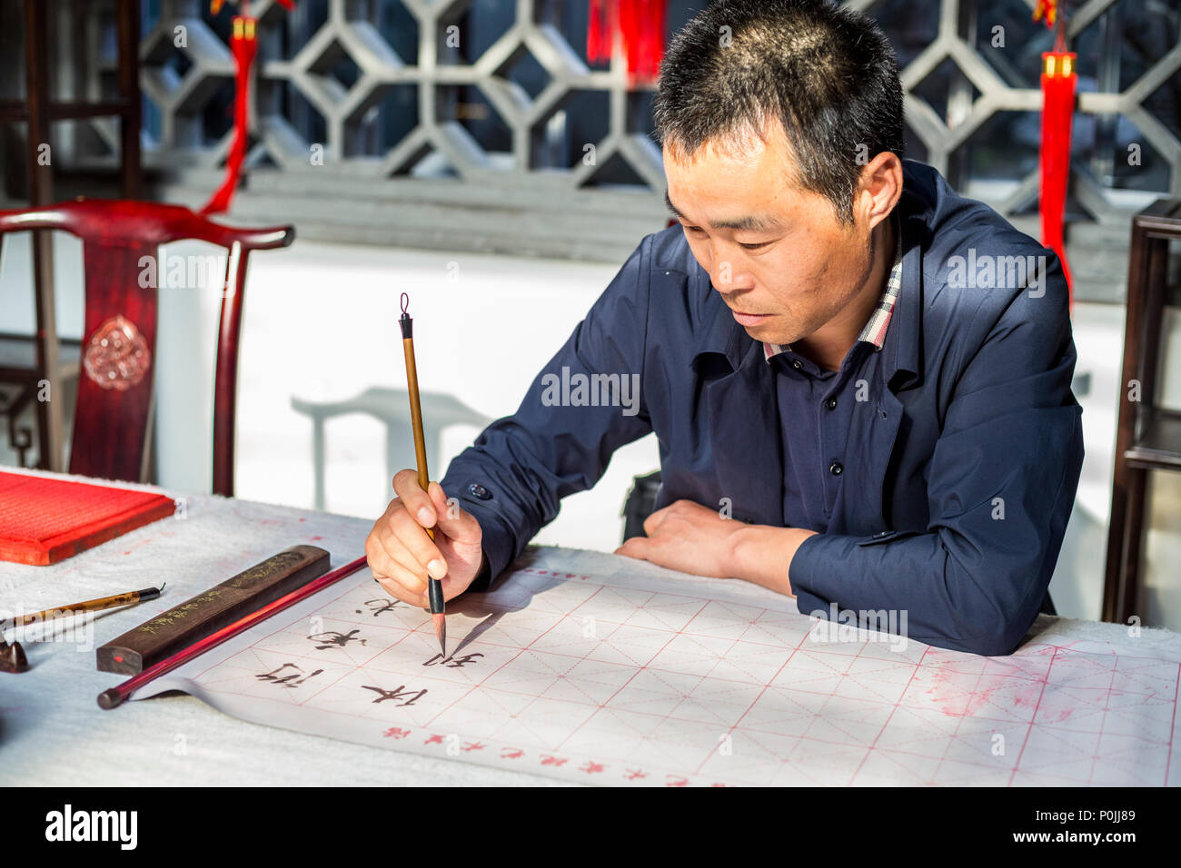 Yangzhou, Jiangsu, Cina. Calligrapher cinesi al lavoro. Foto Stock
