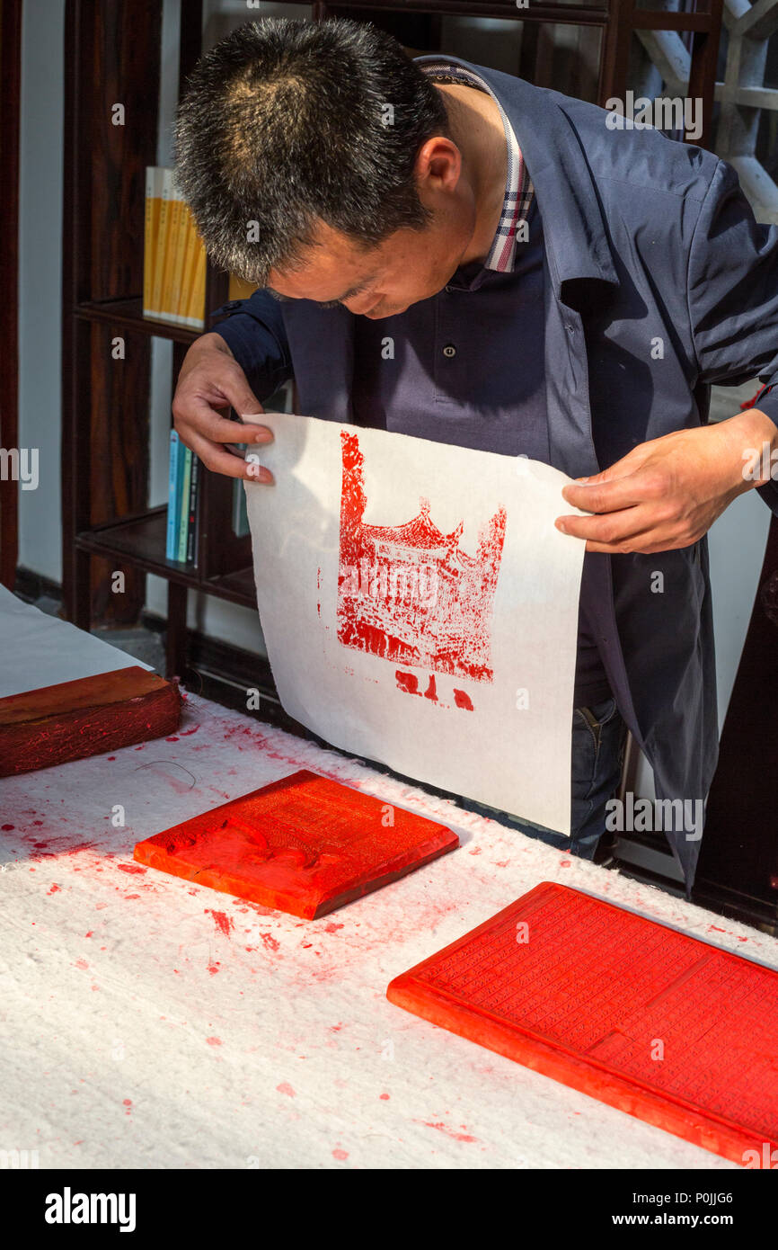 Yangzhou, Jiangsu, Cina. Artista cinese dimostrando blocco tecnica di stampa. Foto Stock