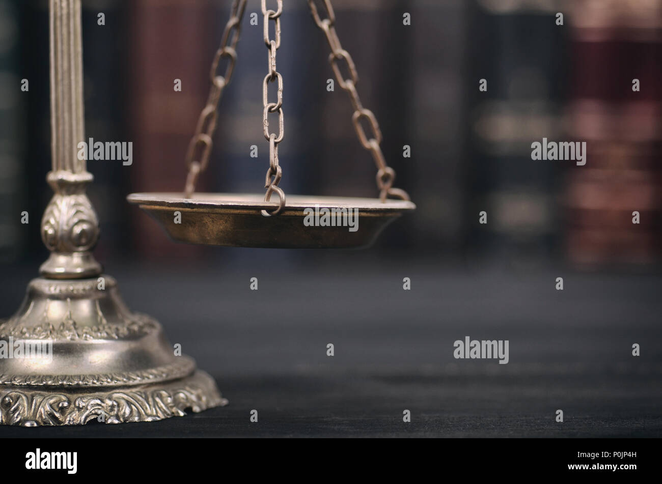 Il diritto e la giustizia, il concetto di legalità, bilancia della giustizia su un nero lo sfondo di legno. Foto Stock