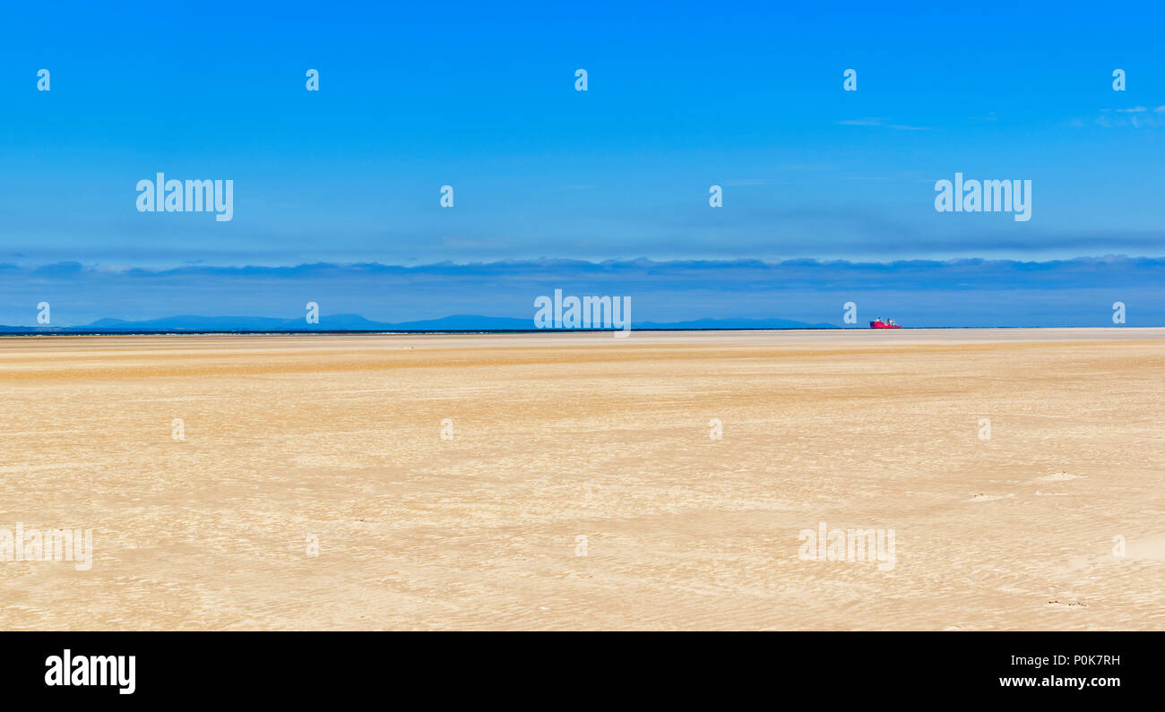 Spiaggia di CULBIN MORAY SCOZIA GUARDANDO VERSO IL BLACK ISLE miglia di spiaggia sabbiosa e nave rossa sull'orizzonte Foto Stock
