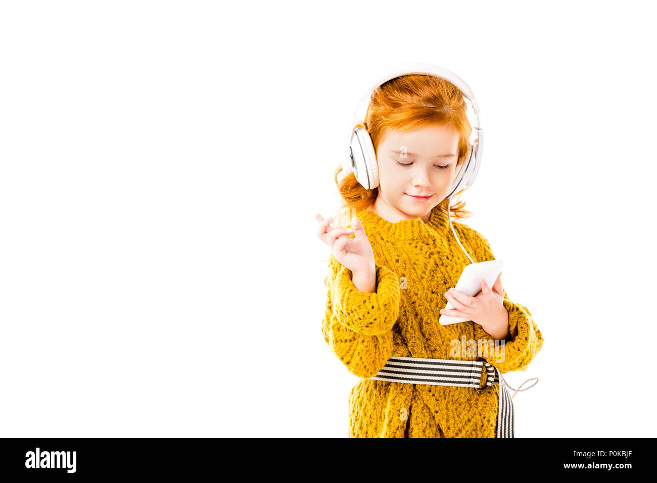 Capelli rossi kid ascoltando musica con lo smartphone isolato su bianco Foto Stock