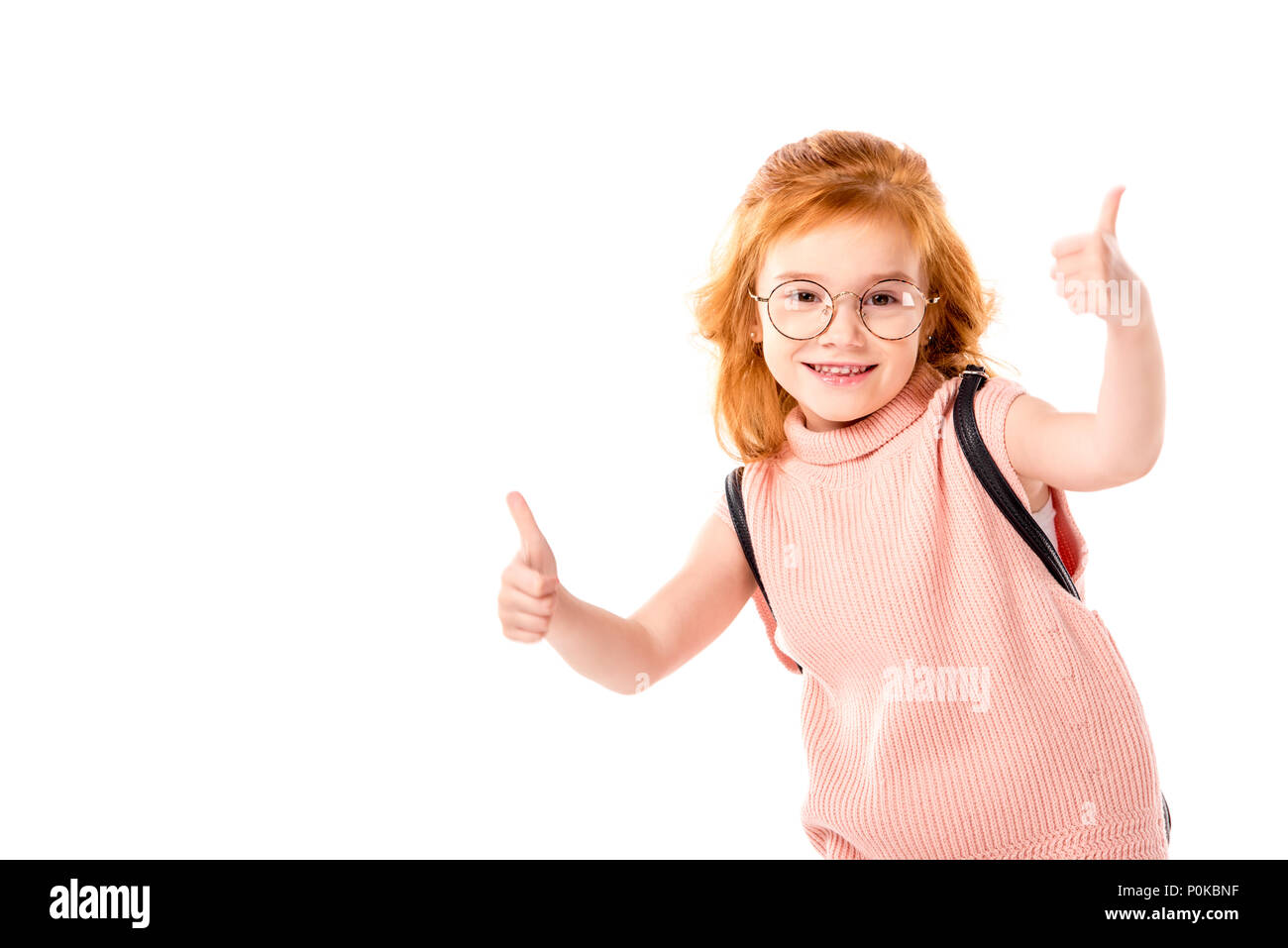 Capelli rossi kid con zaino che mostra pollice in alto isolato su bianco Foto Stock