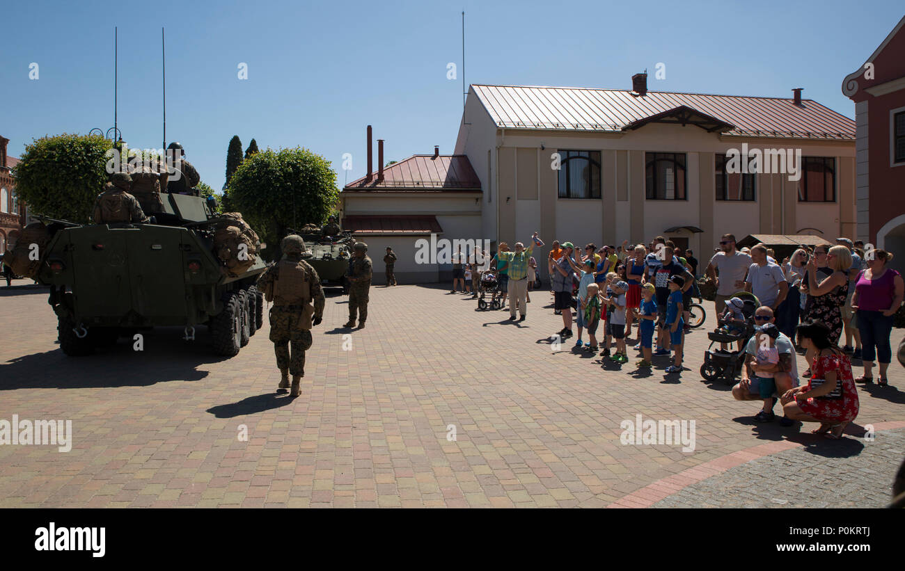 I cittadini di Bauska, Lettonia guarda come NEGLI STATI UNITI Marines dalla quarta luce corazzato battaglione di ricognizione, Delta Co. partono dopo la multinazionale impegno civile cerimonia in Bauska, Lettonia Giugno 2, 2018. Cittadini provenienti da comunità di Bauska sono incoraggiati ad interagire con gli Stati Uniti Marines, guardie della Nazionale Lettone 53a guardia del battaglione di fanteria e di attuare una "hands-on" approccio con i loro veicoli militari. La quarta LAR Marines stanno conducendo una strada marzo dal porto di Klaipeda, Lituania all'area formazione in Adazai, la Lettonia e la conduzione di visualizzazione statica eventi in pochi comunitario locale Foto Stock