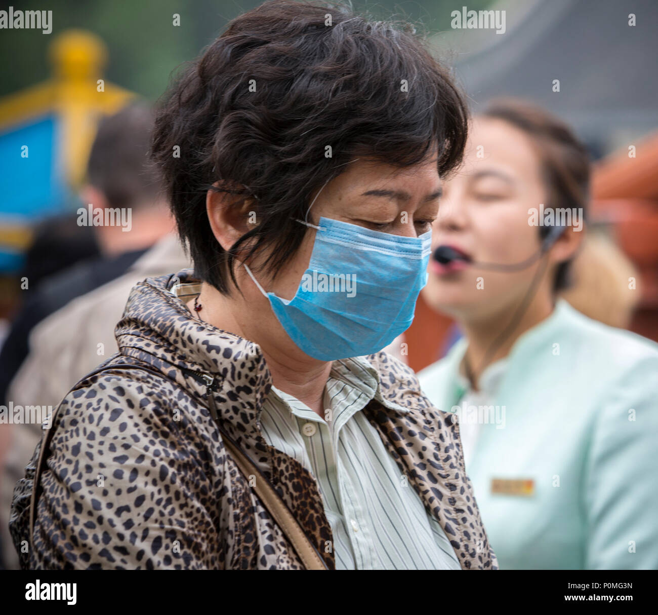 Yangzhou, Jiangsu, Cina. Donna di mezza età che indossa una maschera per la respirazione. Snello West Lake Park. Foto Stock