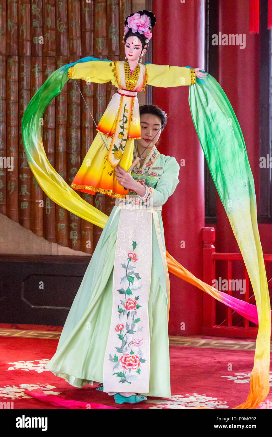 Yangzhou, Jiangsu, Cina. Giovane donna di eseguire la danza tradizionale con la bambola e tessuto di vorticazione, snello West Lake Park. Foto Stock
