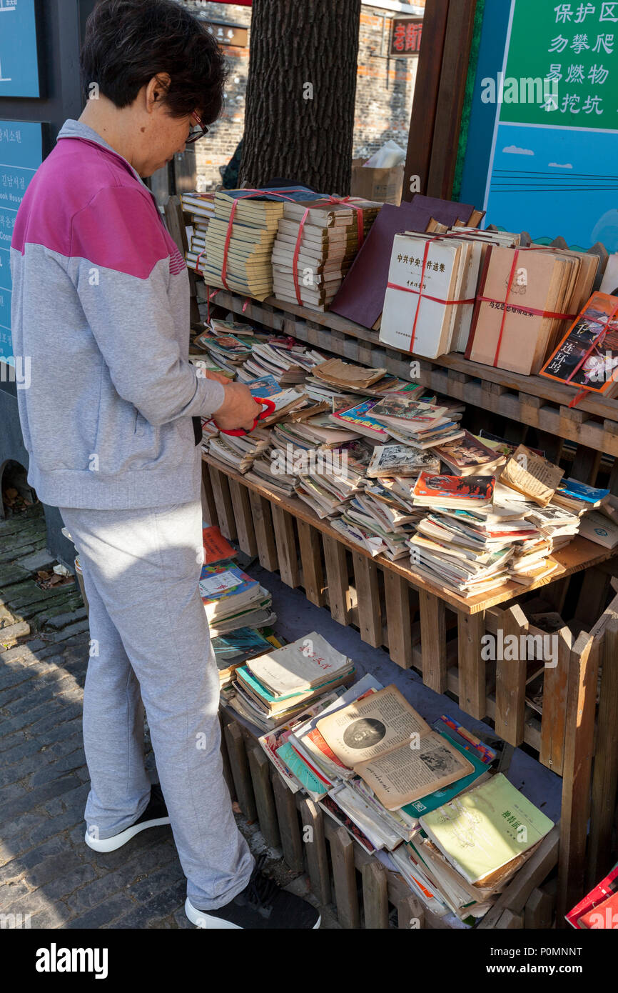 Yangzhou, Jiangsu, Cina. Clienti alla ricerca di libri usati, Dong Guan Street. Foto Stock