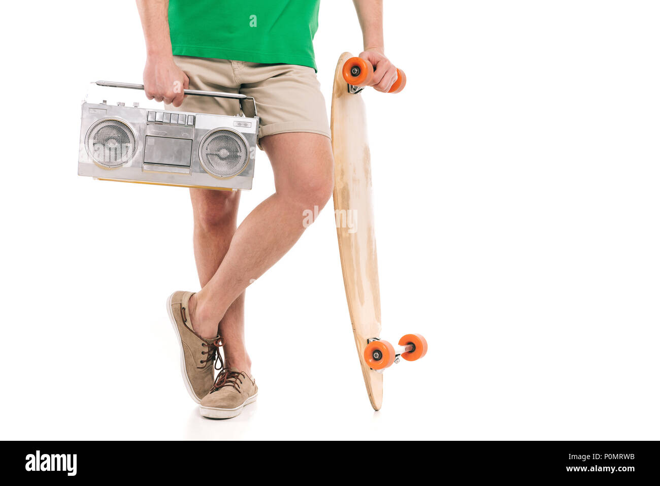 Ritagliato colpo di giovane uomo in shorts holding skateboard e registratore a nastro isolato su bianco Foto Stock