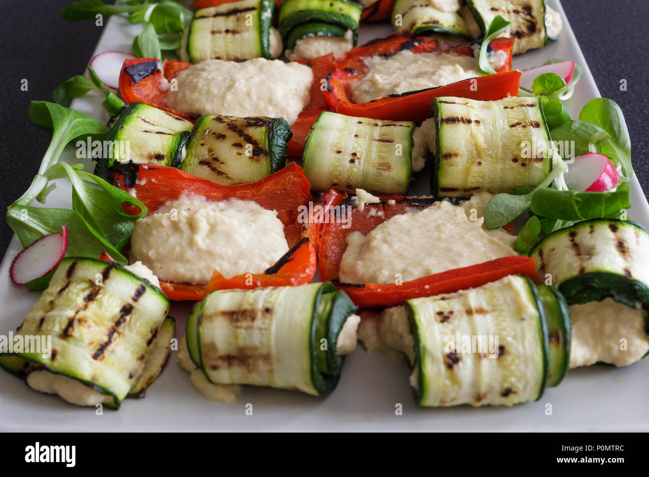 Peperoni e zucchine con hummus salsa. Una miscela di piatti mediterranei e cucina araba. La cucina casalinga. Foto Stock