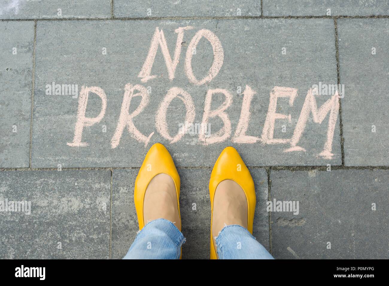 I piedi femminili con testo nessun problema scritto sul marciapiede grigio. Foto Stock