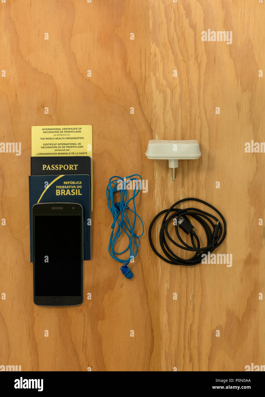 Travelig in Brasile: essenziale per un viaggio di cui su una tavola di legno: due passaporti e certificato internazionale di vaccinazione e telefono cellulare Foto Stock