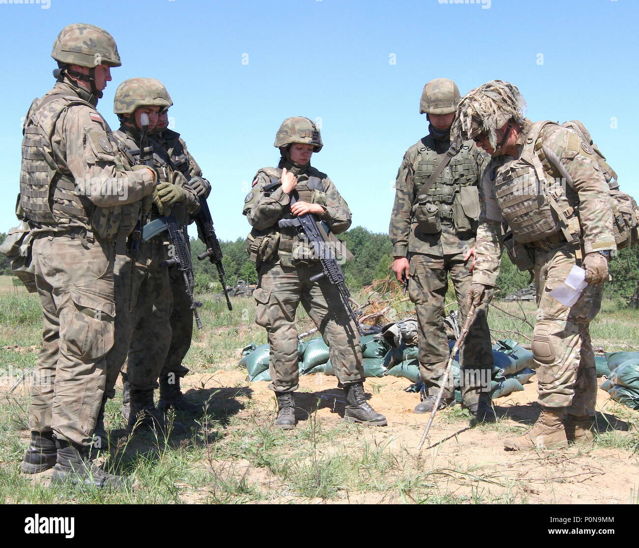 Stati Uniti Il personale dell'esercito Sgt. Marion Szwcyk, armi leader di squadra, dalla truppa di Apache, 1° Stormo, 2° reggimento di cavalleria, Battle Group Polonia incarica esercito polacco i soldati della XV Brigata meccanizzata di spazio necessario per scavare un posizioni di combattimento durante lo sciopero di Saber 18 in Wyreby, Polonia il 7 giugno 2018. Sciopero di Saber 18 è l'ottava iterazione della lunga U.S. Esercito Europa-led formazione cooperativa esercizio progettata per migliorare l'interoperabilità tra alleati e partner regionali. (Michigan esercito nazionale Guard foto da 1Lt. Erica Mitchell/ rilasciato). Foto Stock