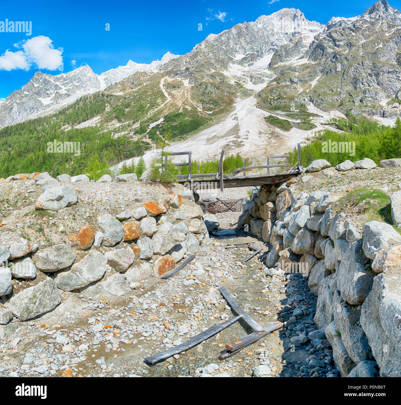 Ponte pedonale distrutto da una valanga in inverno, il paesaggio in Val Ferret con le montagne delle Grandes Jorasses in background Foto Stock