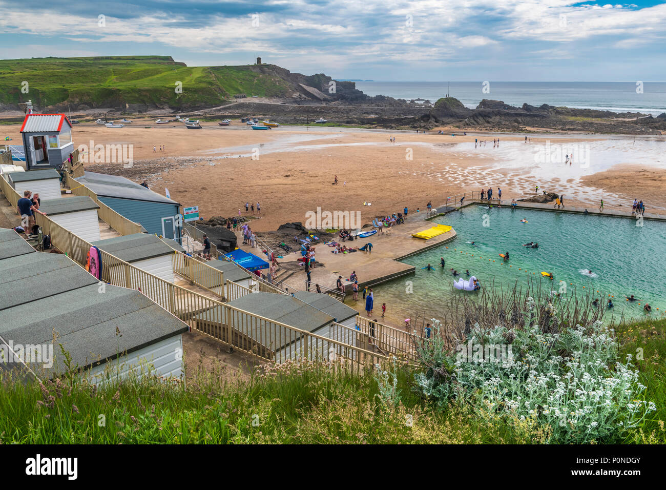 In una giornata di sole, le persone godono il recentemente ristrutturato aria aperta seapool sul lungomare a Bude in North Cornwall. Foto Stock