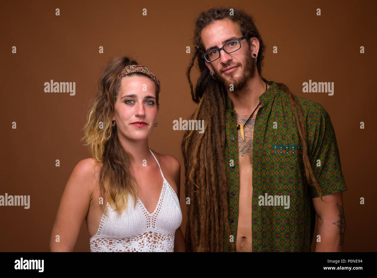 I giovani ispanici coppia insieme contro lo sfondo marrone Foto Stock