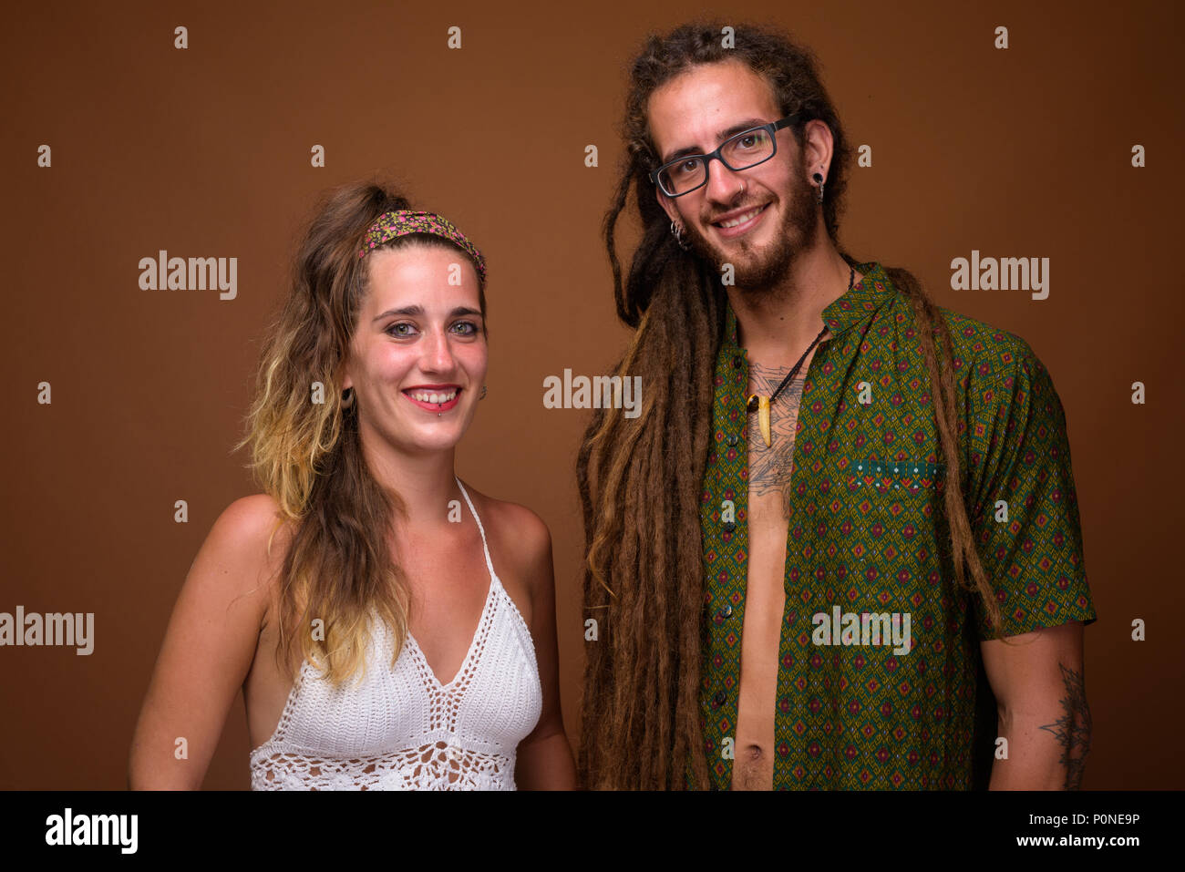 I giovani ispanici coppia insieme contro lo sfondo marrone Foto Stock