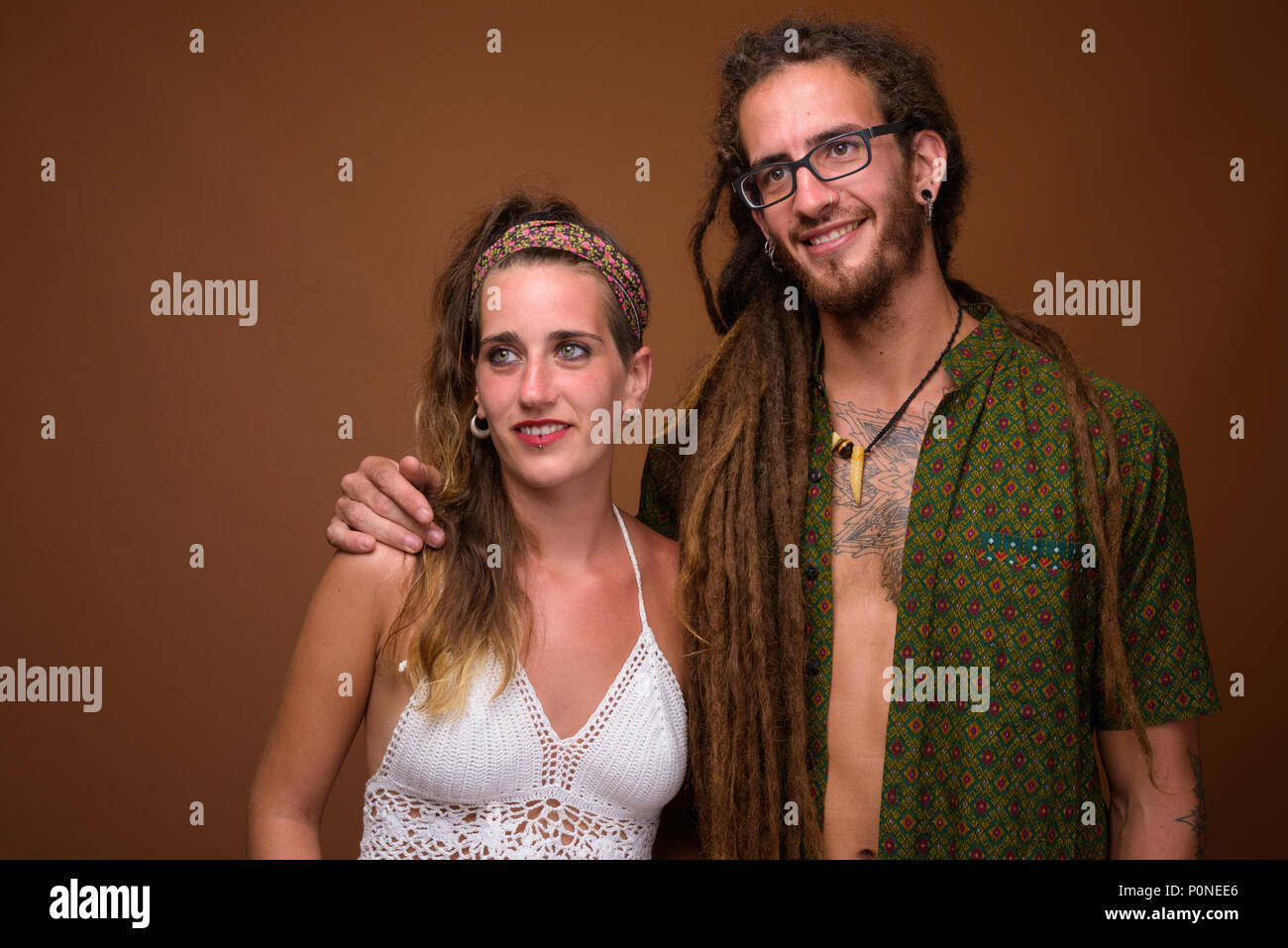 I giovani ispanici coppia insieme contro lo sfondo marrone Foto Stock