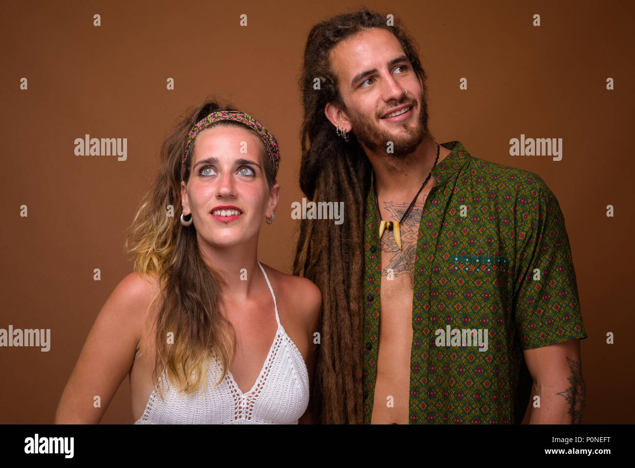 I giovani ispanici coppia insieme contro lo sfondo marrone Foto Stock