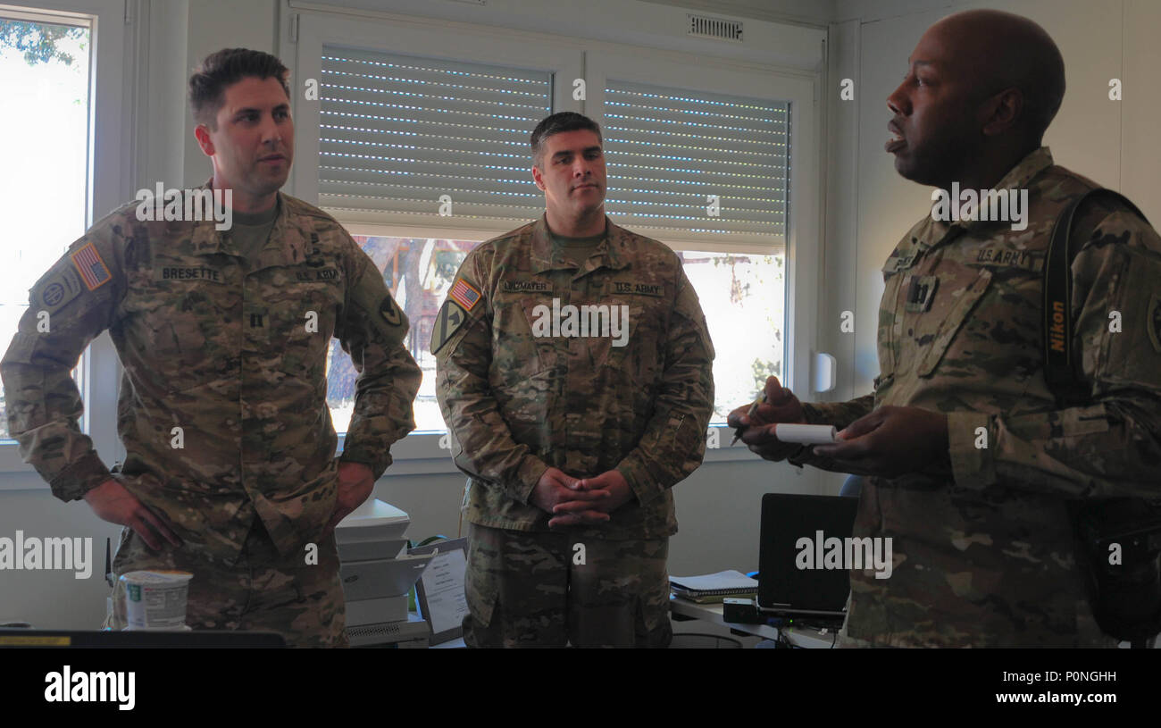 Esercito Capt. Michael Bresette (sinistra), assegnato al 928 Contratto battaglione del Team (CTB), 409 contraente brigata di supporto (CSB), e l'esercito Capt. Erik Linzmayer (centrale), assegnato al 632 CBT, 409 CSB, parla con esercito Capt. Ellis parchi (destra), assegnato al 382 Affari pubblici distacco attaccata al 1° Brigata corazzate contro la squadra, 1° Distaccamento di cavalleria di ufficio per gli affari pubblici, per quanto riguarda le operazioni di contraenti in Zagan, Polonia, 7 giugno 2018. La 928 CTB hanno creato più di 20 contratti per un valore di più di mezzo milione di dollari dall'inizio dell'estate europea combattuta stagione. ( Foto Stock