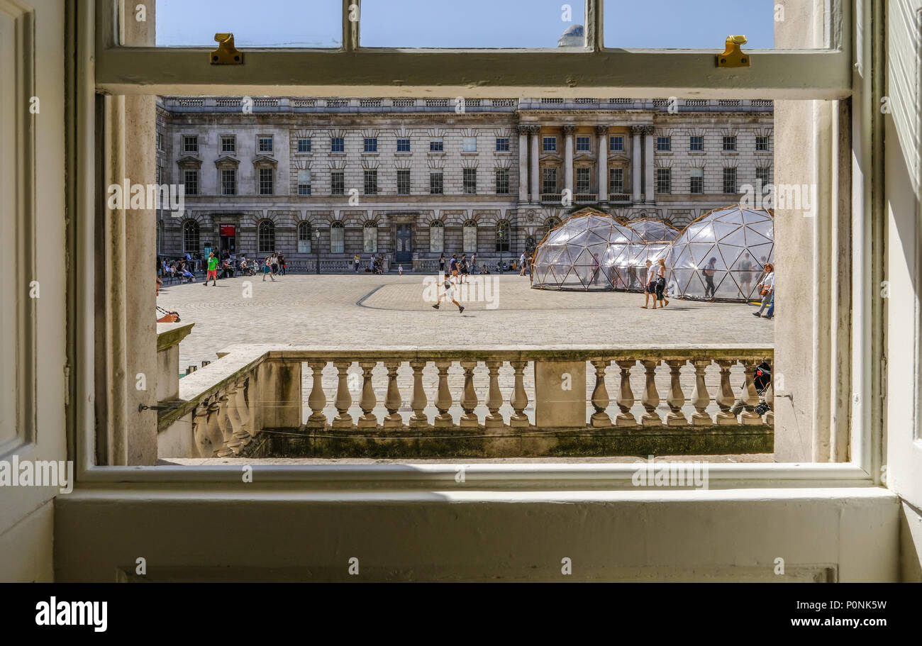 La Somerset House, London, Regno Unito - 22 Aprile 2018: vista guardando fuori da una finestra ad anta a Somerset House. Mostra le cialde di inquinamento con i turisti nel centro sq Foto Stock